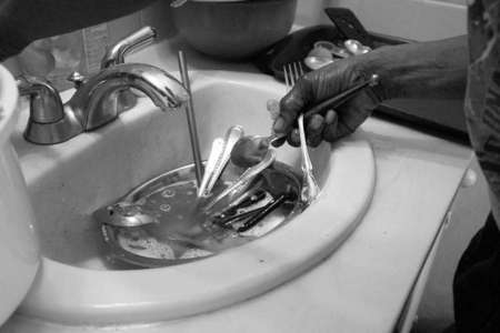 With no kitchen sink to clean her family's dishes, Denise uses the motel room's bathroom sink to wash and dry their silverware. 